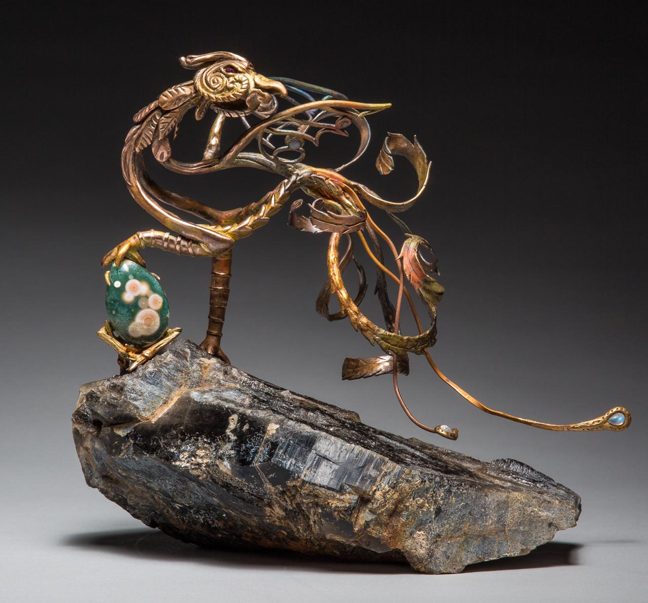 metal sculpture: phoenix on rock